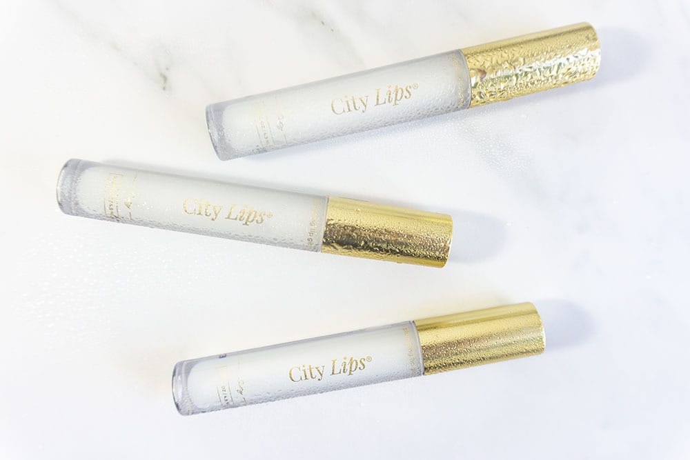 clear lip gloss on white marble background