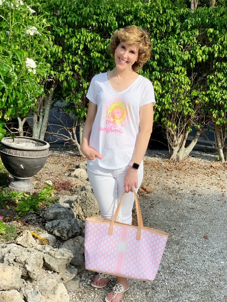 woman carrying pink bag in garden setting on sanibel beach trip travel outfit