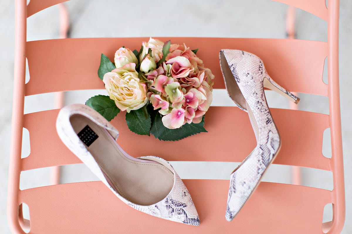 snake embossed pumps and a flower bouquet on a striped background