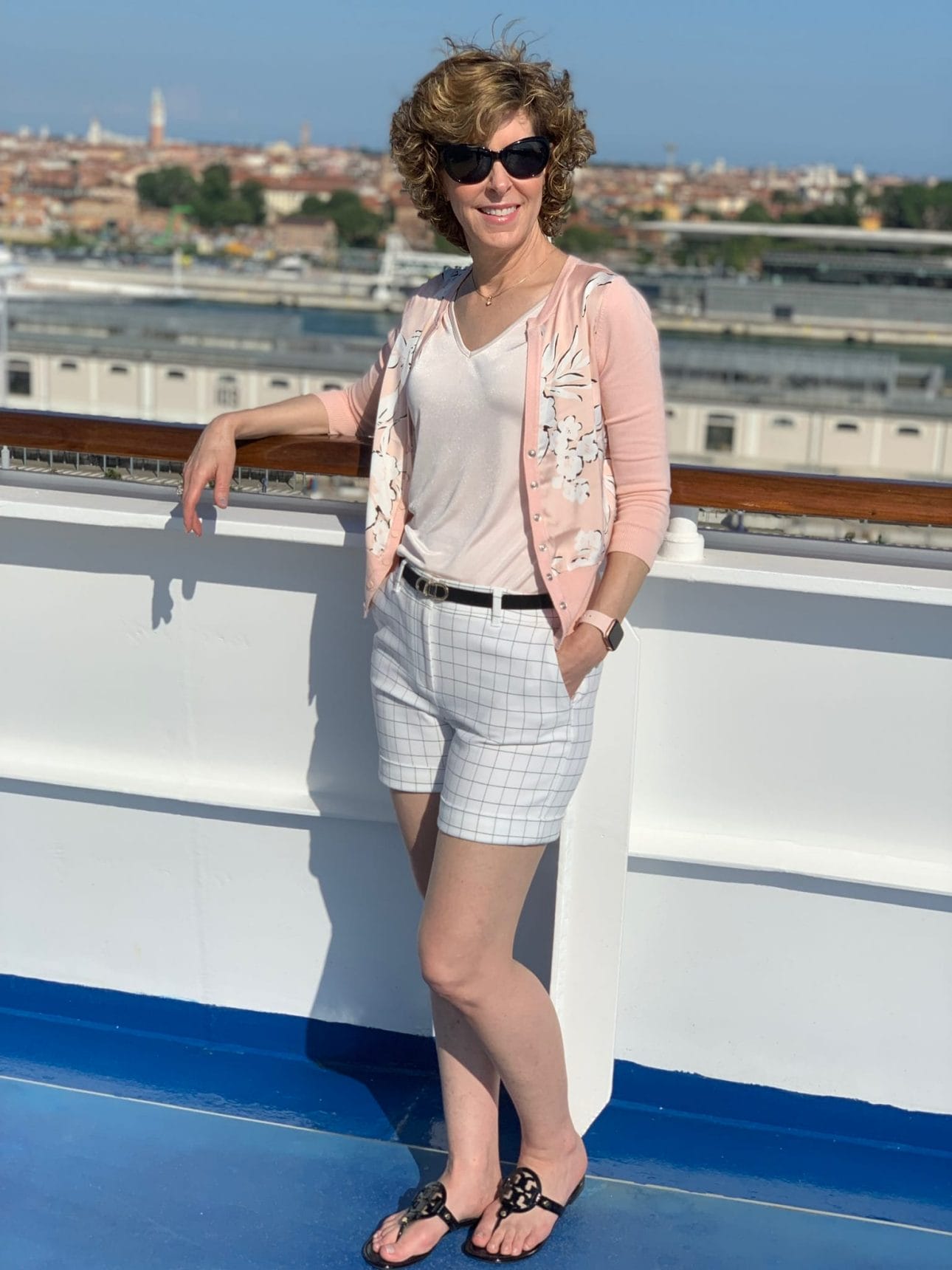 woman posing by rail of a cruise ship