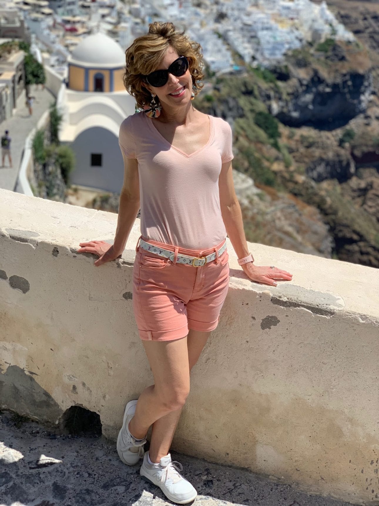 woman posing by a wall in santorini greece