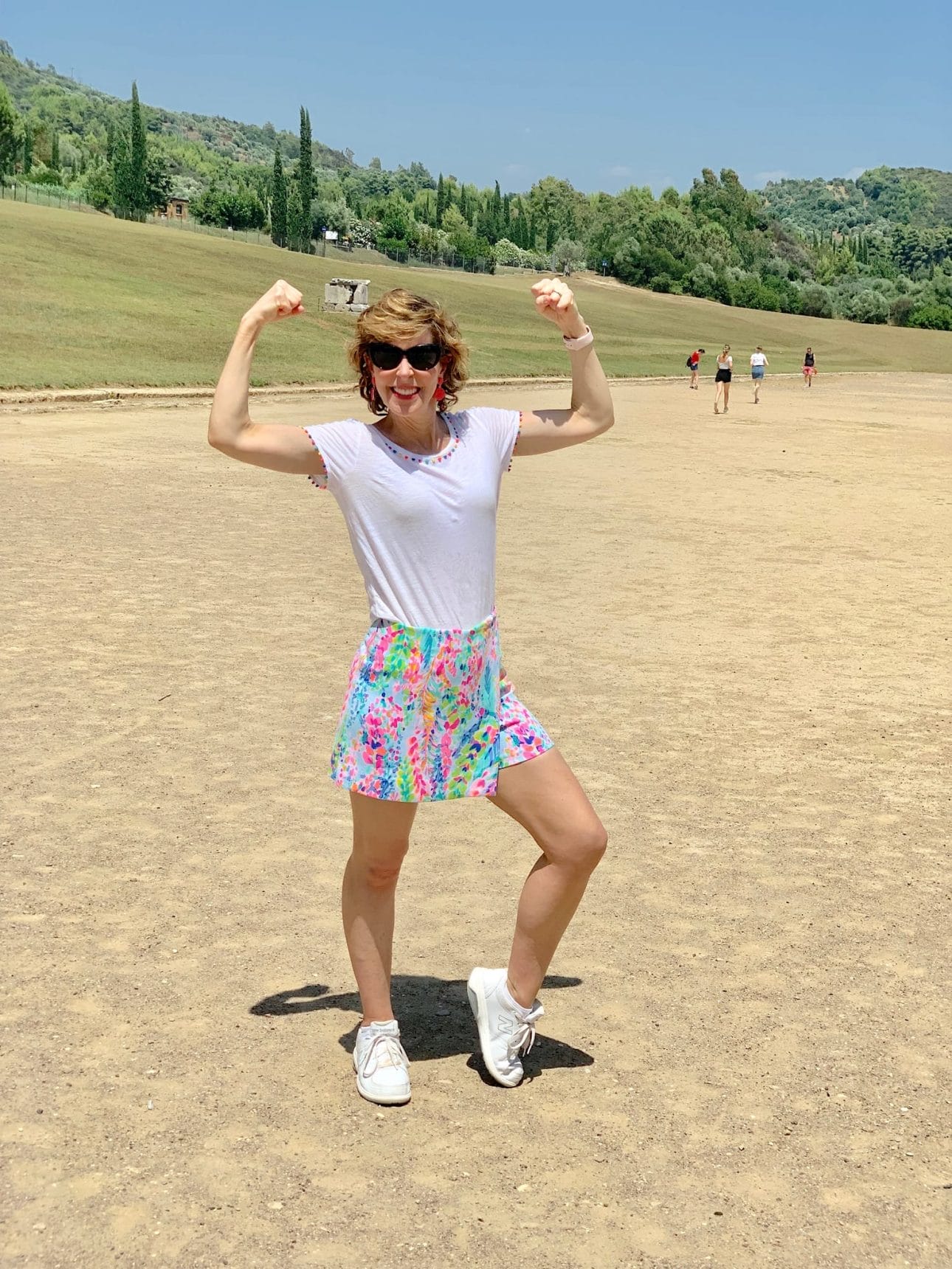 women flexing biceps on a field at the site of the first olympics in olympia greece