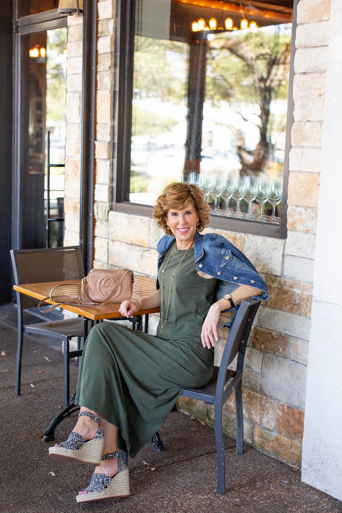 woman in green dress sitting at a restaurant patio table