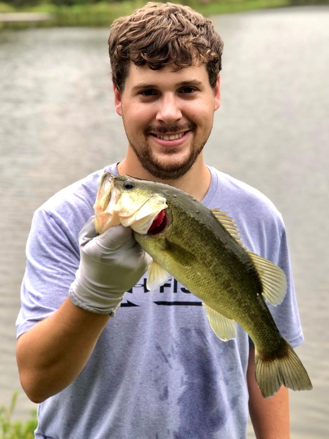 young man holding bass caught at long cove
