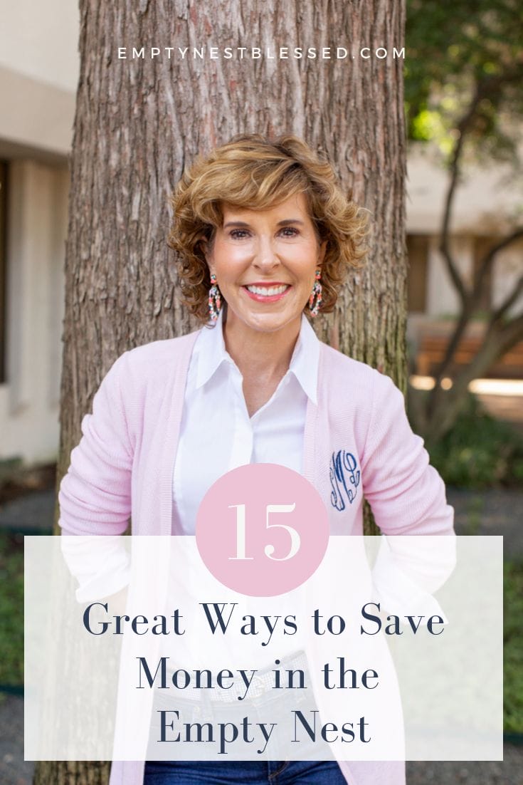 woman in pink monogram cardigan standing by a tree and looking at the camera with graphics saying 15 ways to save money in the empty nest