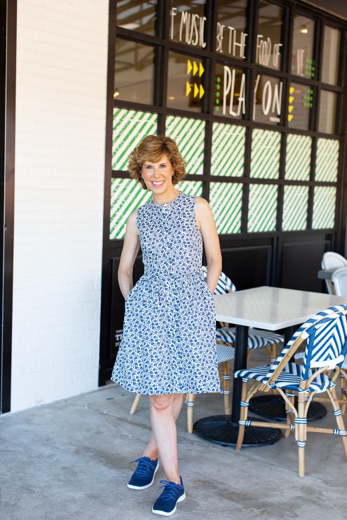 woman in blue floral dress on a restaurant patio