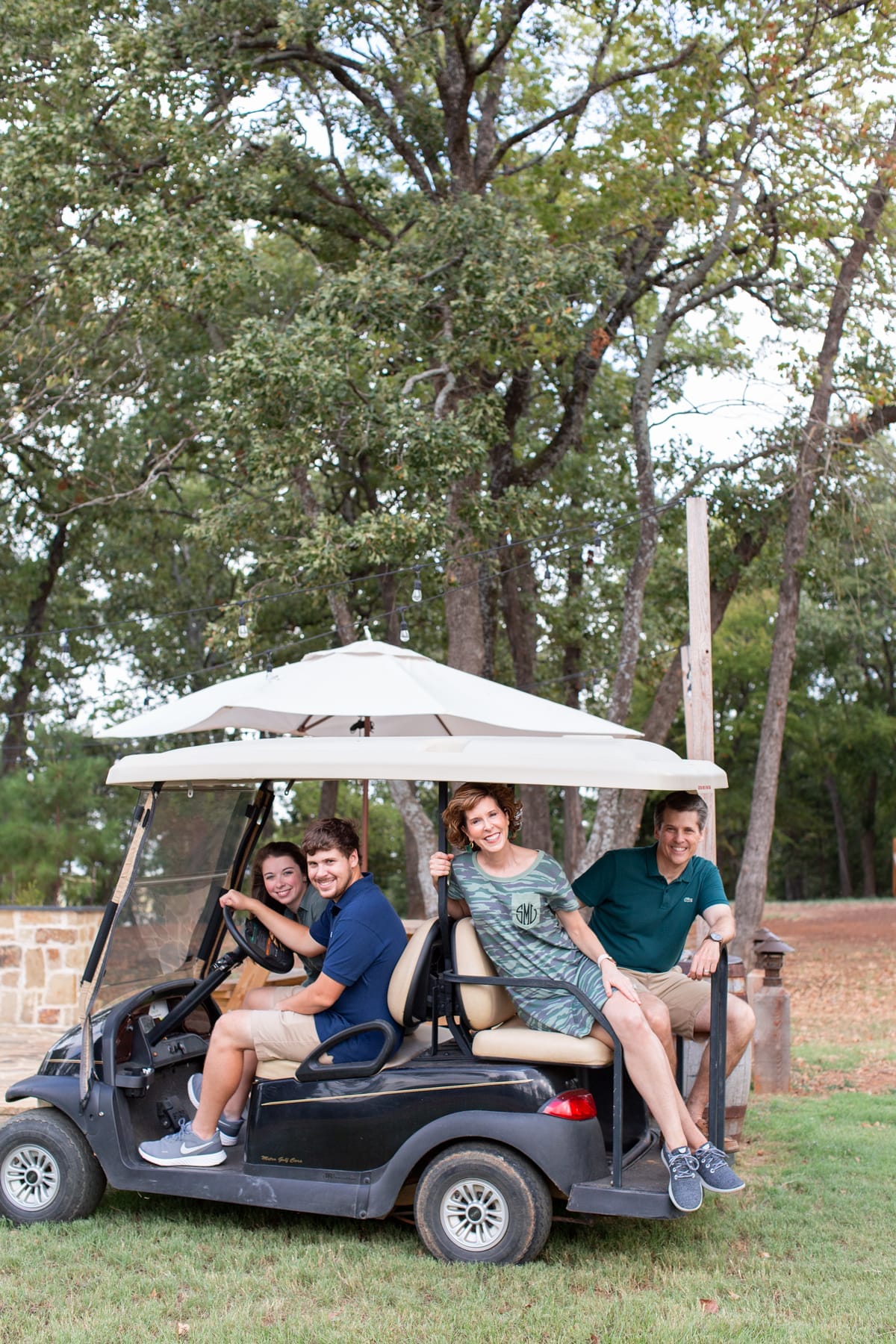 a family of four riding on a golf cart