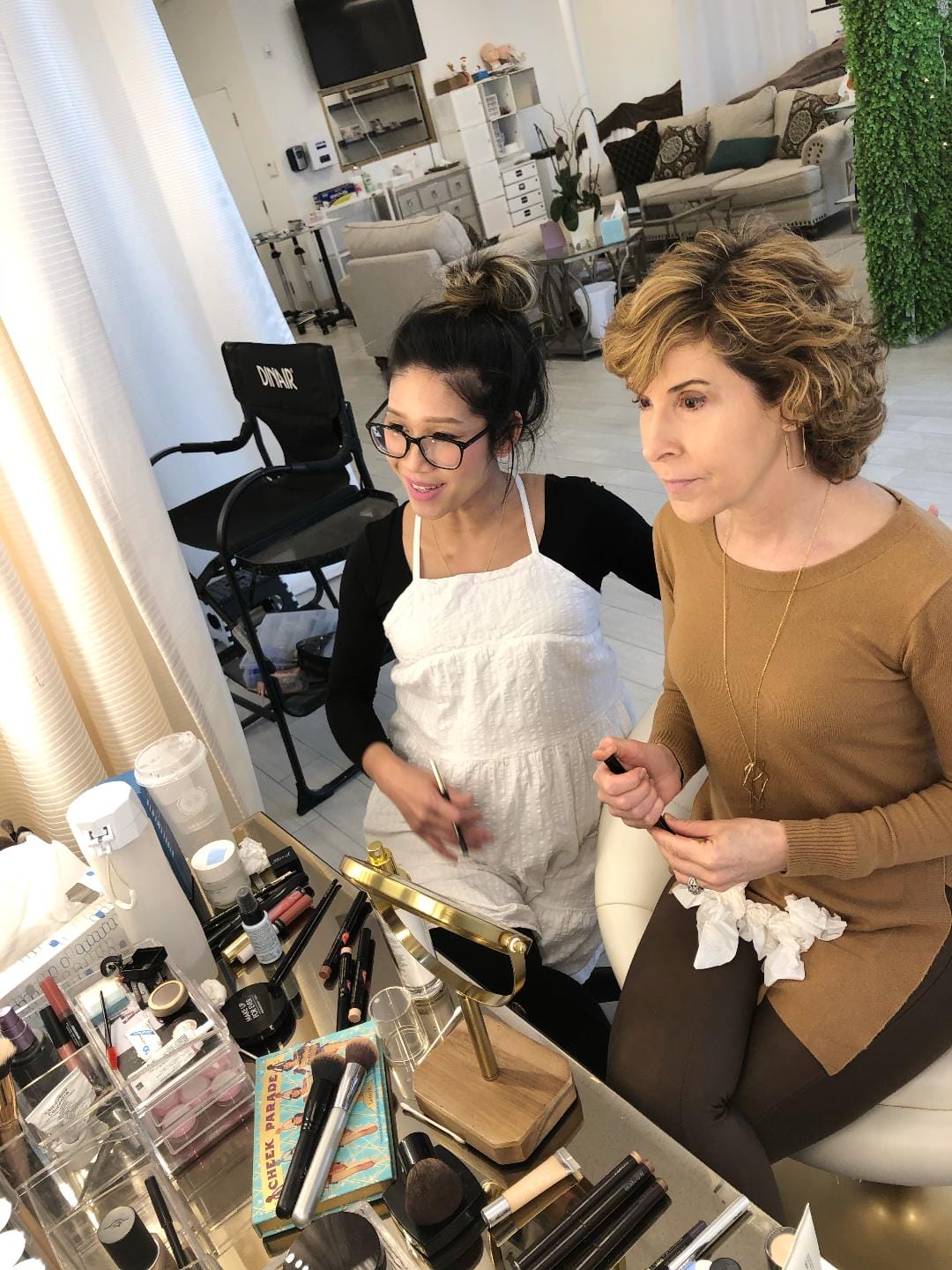 woman looking into makeup mirror during a makeup lesson