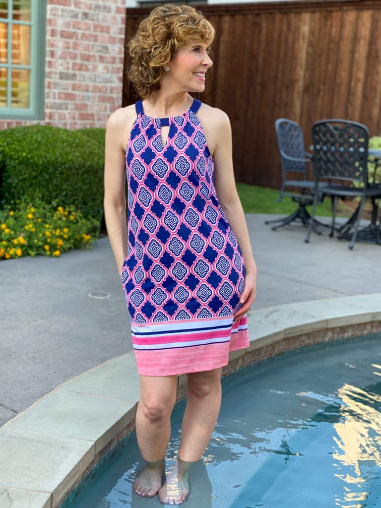woman in blue and pink dress posing by the side of a pool