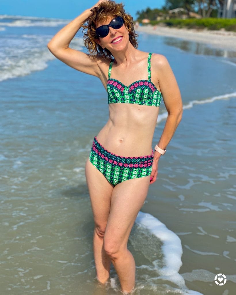 woman posing in green print Boden bikini on the beach
