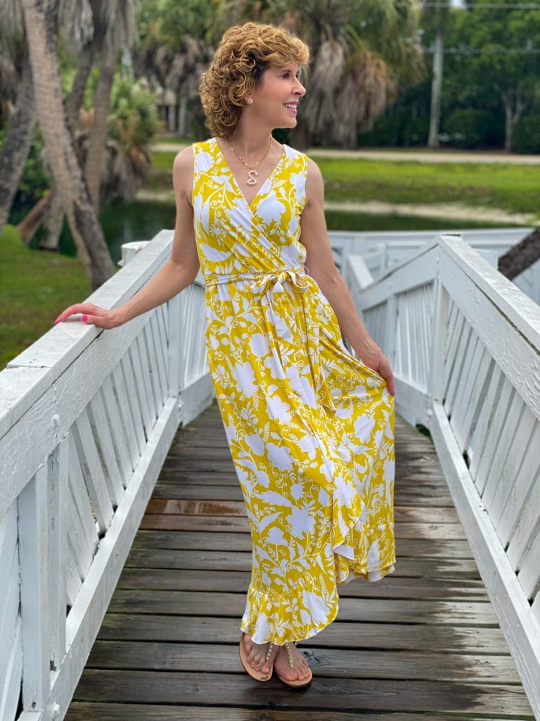 woman in yellow maxi dress standing on a white bridge