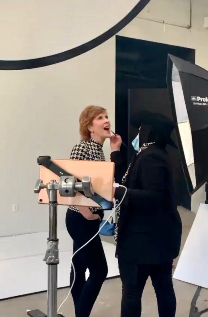 woman getting makeup done at photo shoot