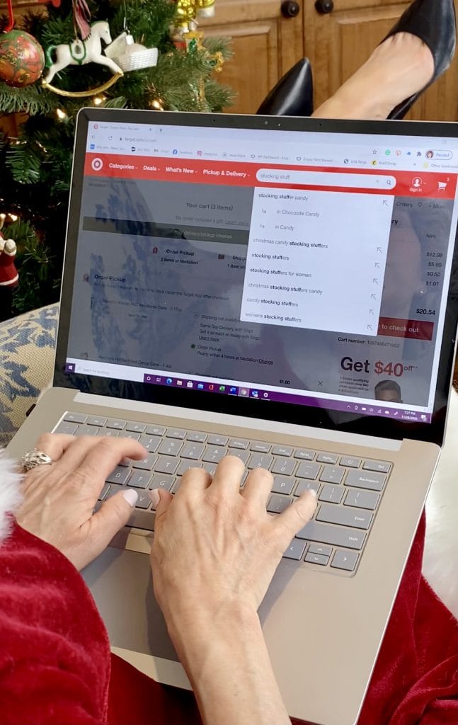 woman safe online shopping on her phone with christmas tree in background