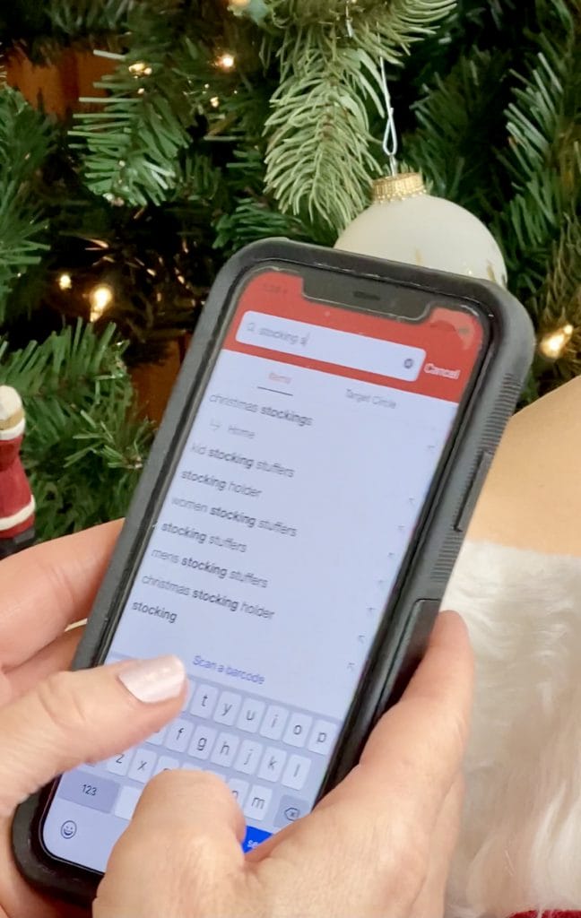 woman shopping on phone with christmas tree background