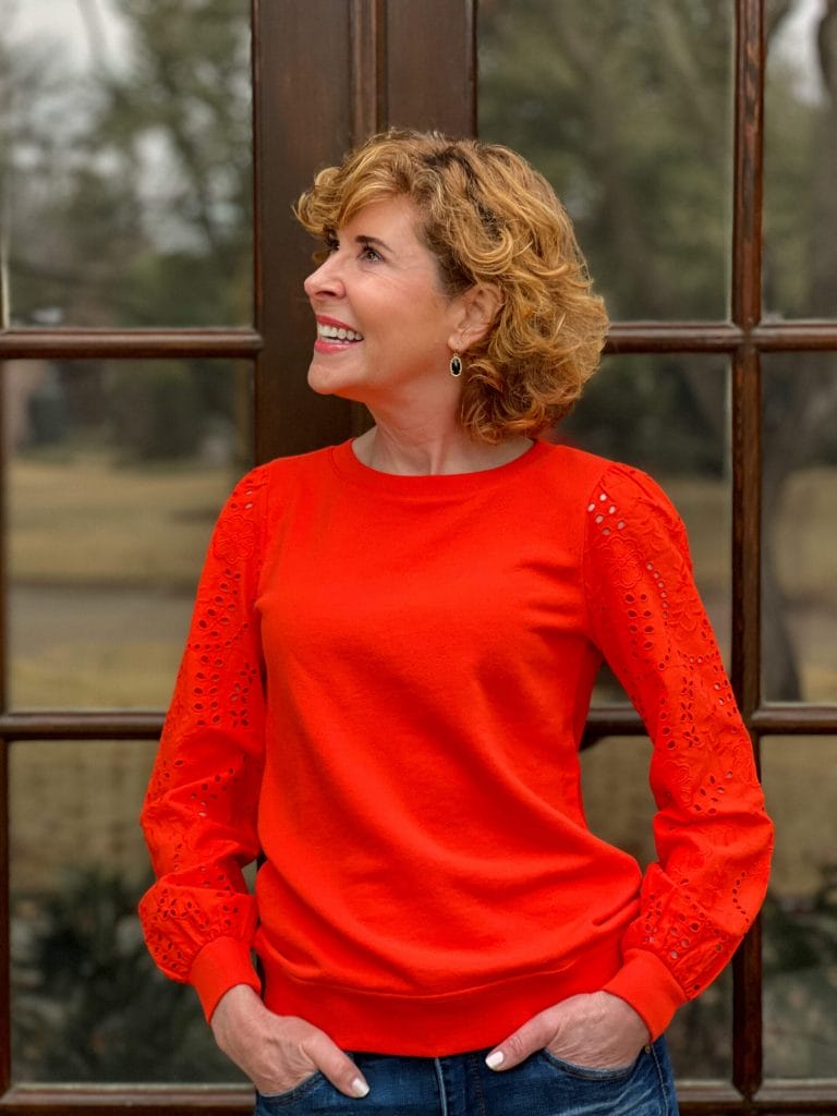 woman looking to the side wearing talbots Eyelet Sleeve Crewneck Sweatshirt standing on porch