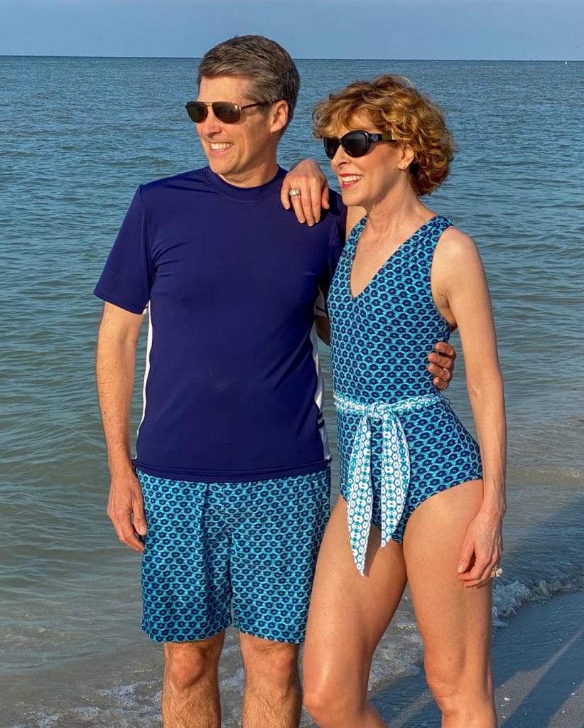 middle age couple in swimsuits posing on the beach