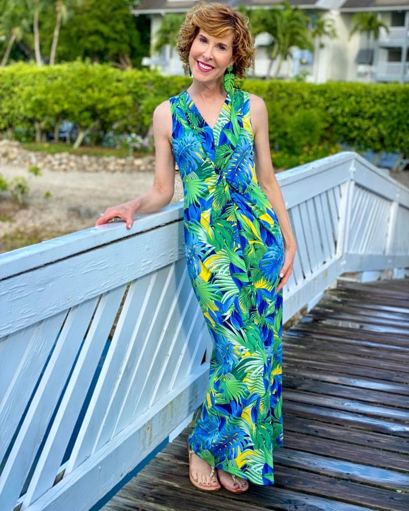 woman over 50 tommy bahama Hot Tropic Maxi Dress and jcrew factory palm earrings posing on a white bridge in a tropical location