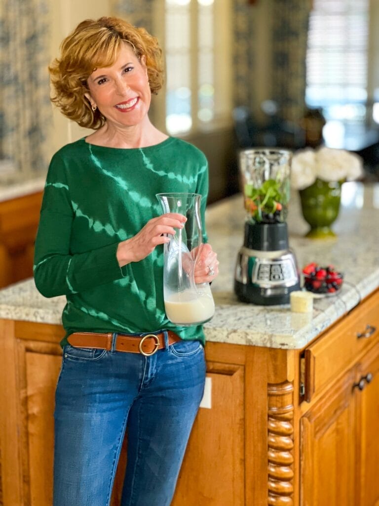 woman over 50 wearing jjill while making a smoothie