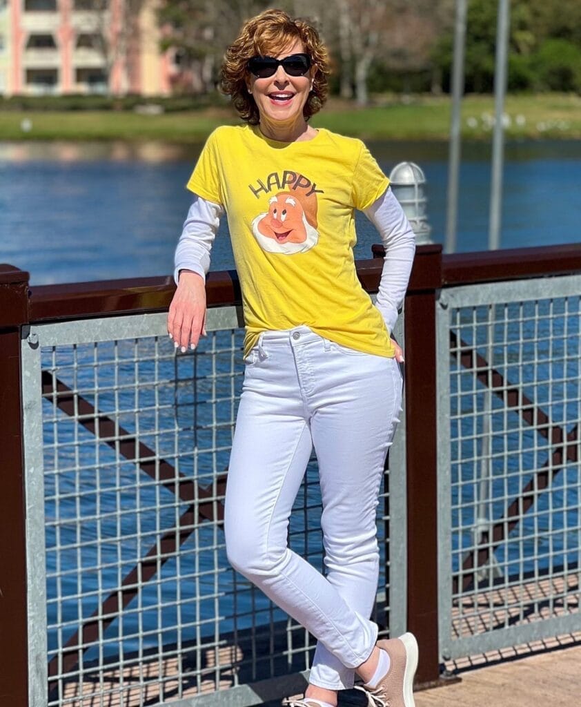 woman wearing happy 7 seven dwarfs shirt standing on a bridge at disney springs