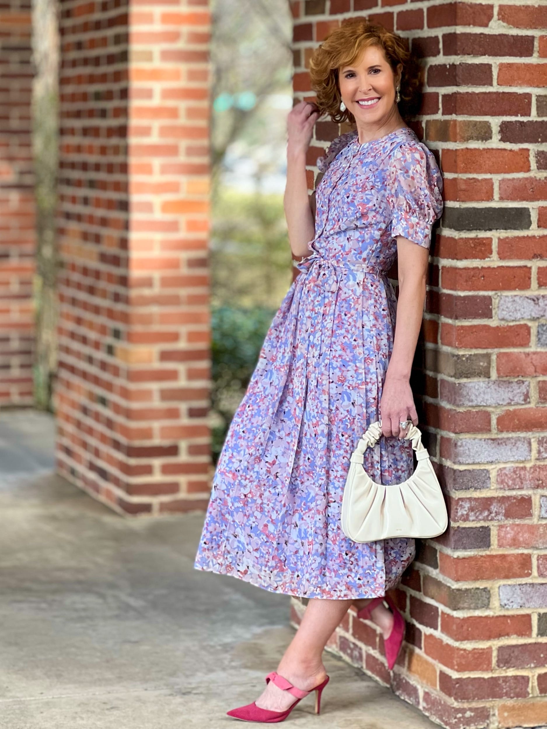 woman over 50 wearing Chelsea28 Floral Puff Sleeve Midi Dress from Nordstrom leaning against a brick wall