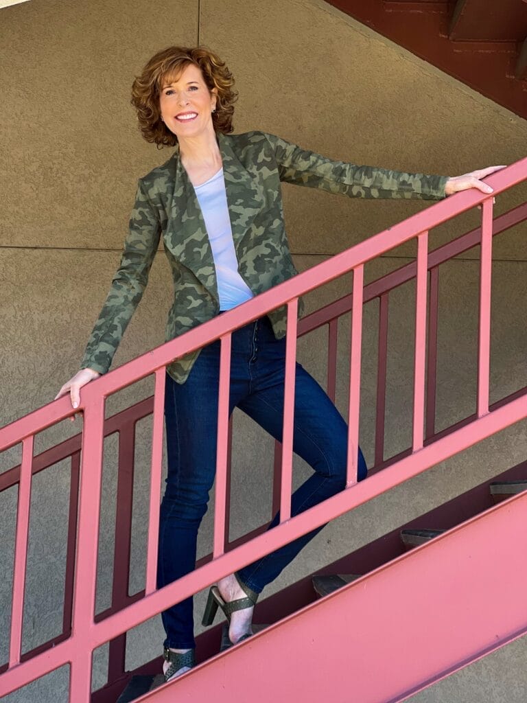 woman over 50 standing on staircase wearing transition your wardrobe from winter to spring in this Drape Collar Knit Blazer and blue jeans from nordstrom