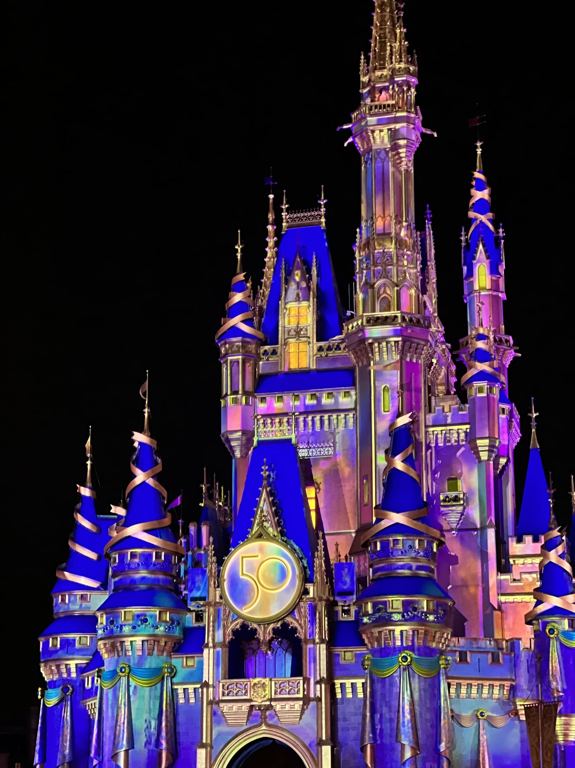 Cinderella's castle lit up at night during Disney's 50th anniversary celebration