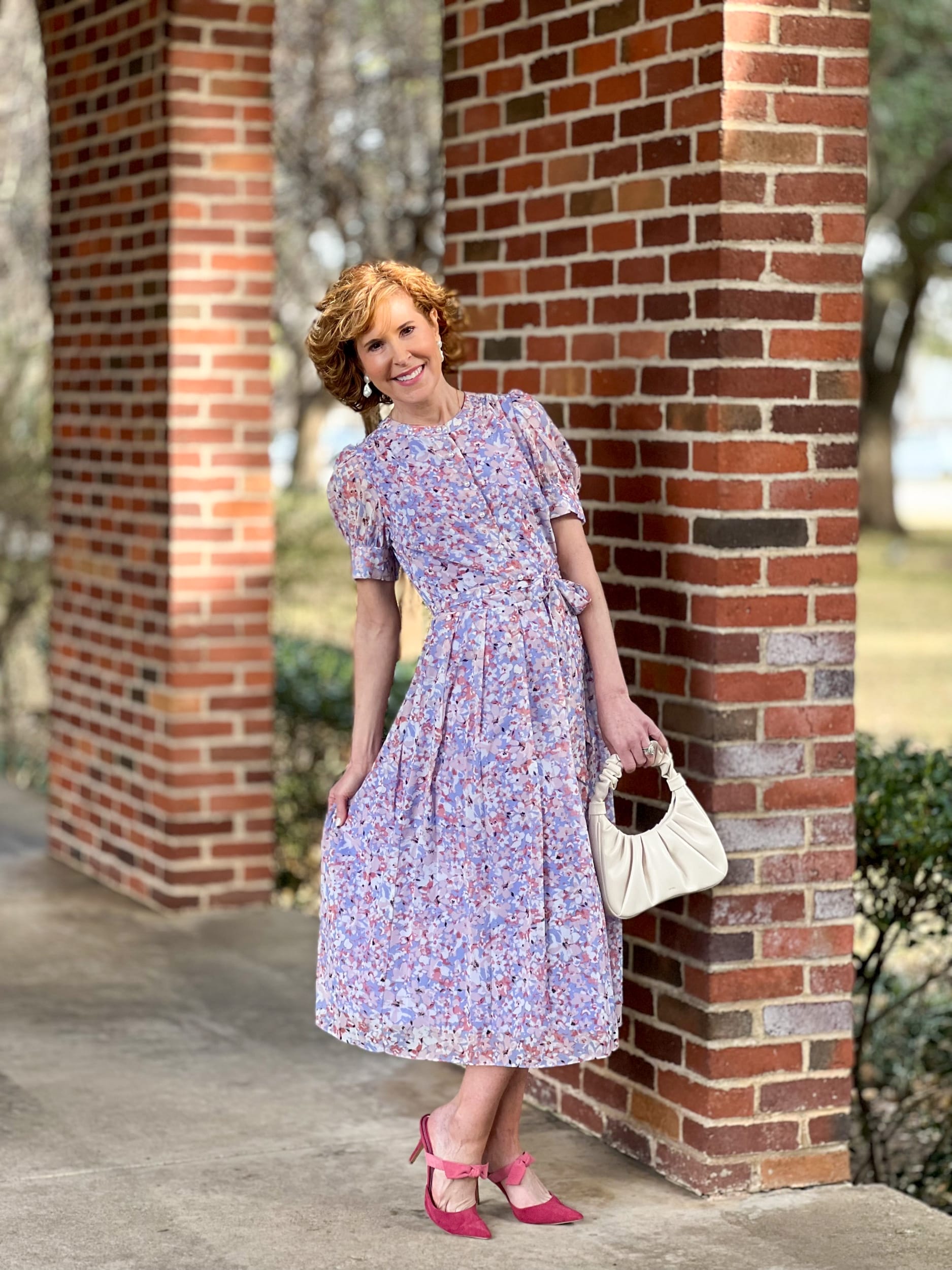 woman over 50 wearing Chelsea28 Floral Puff Sleeve Midi Dress from Nordstrom leaning against a brick wall