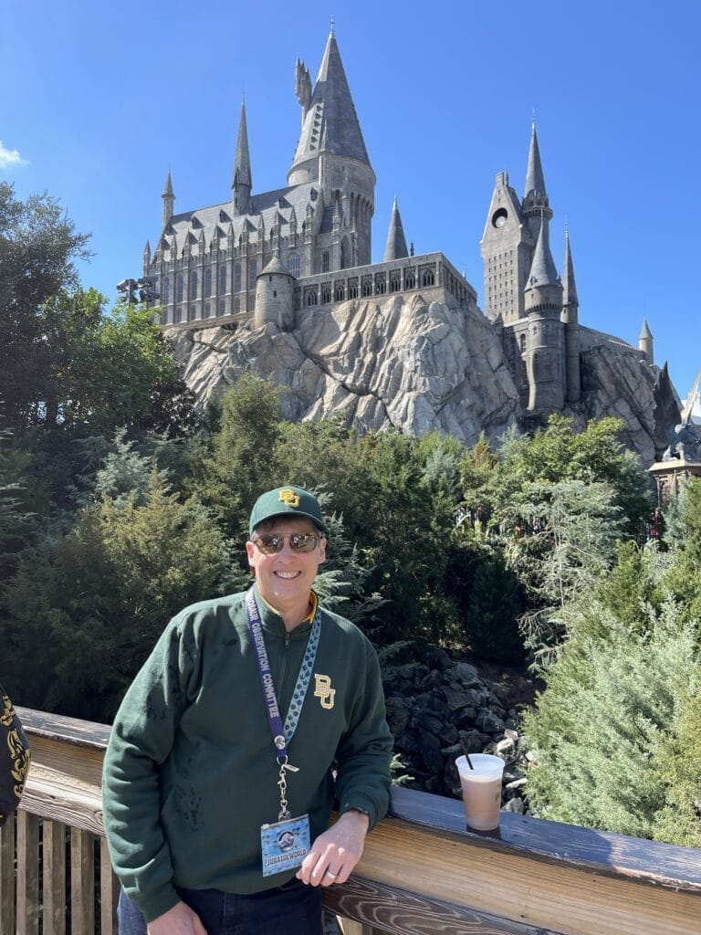 man standing in front of hogwarts at Universal Orlando