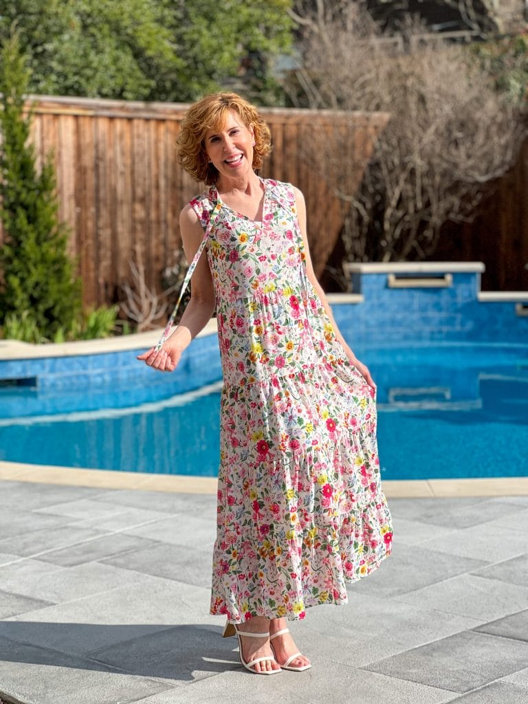 woman standing by a swimming pool wearing Caslon Floral Print Sleeveless Maxi Dress from Nordstrom getting ready for answering your questions