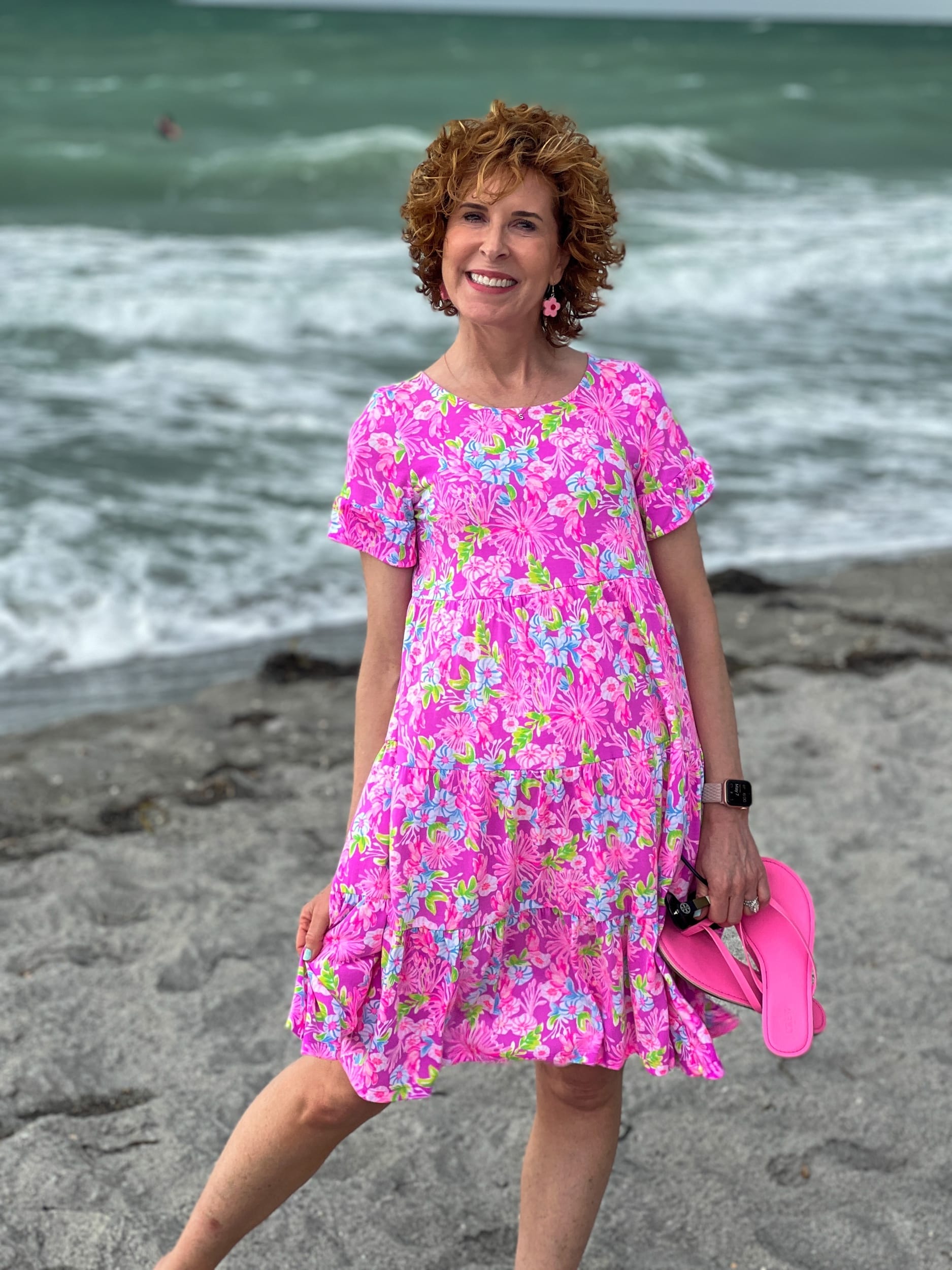 woman over 50 standing on the beach wearing a beach outfit