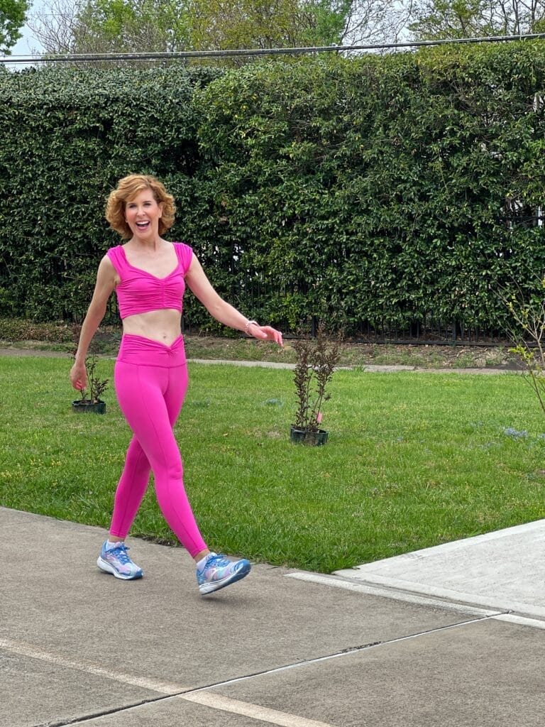 woman over 50 walking for health on walking path wearing free people Movement Breathe Deeper Leggings and crop top