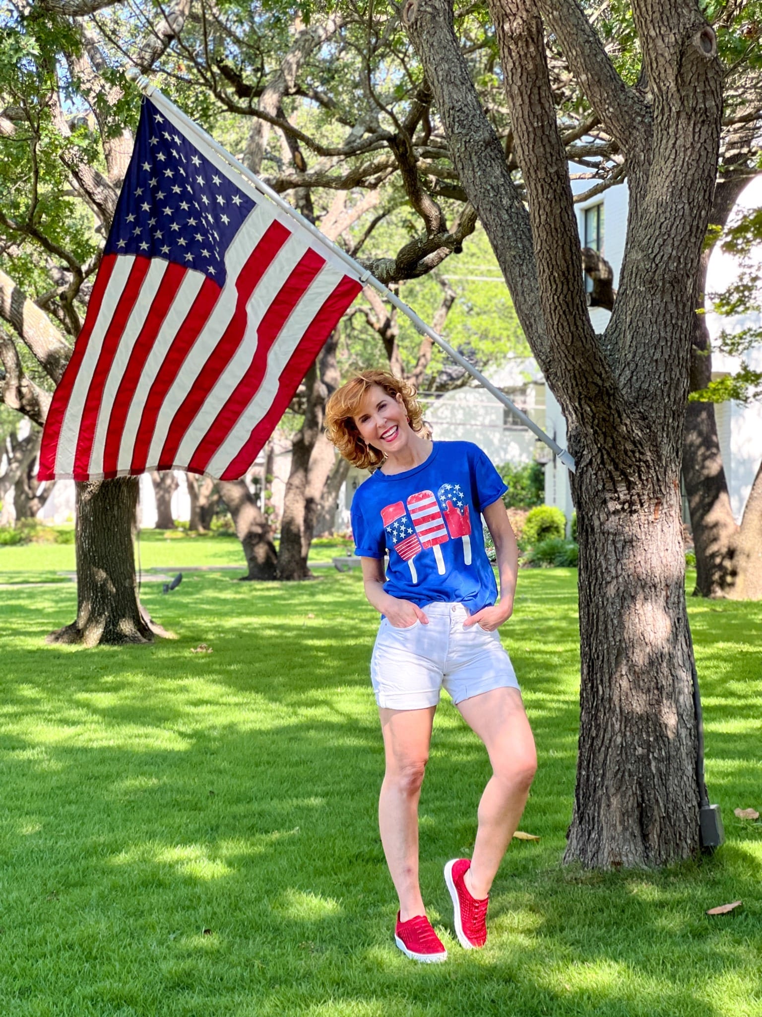 woman wearing patriotic shirt posing by usa flag