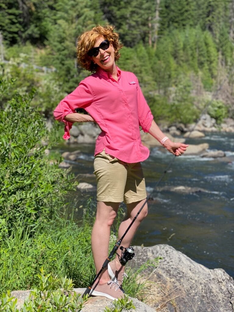 woman fishing o a river in Idaho wearing sun protrective clothing from columbia