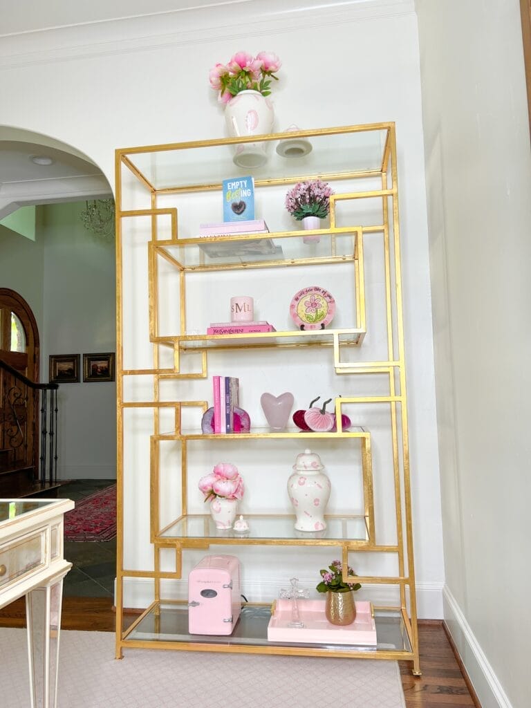 glass and brass shelving unitl in pink themed home office