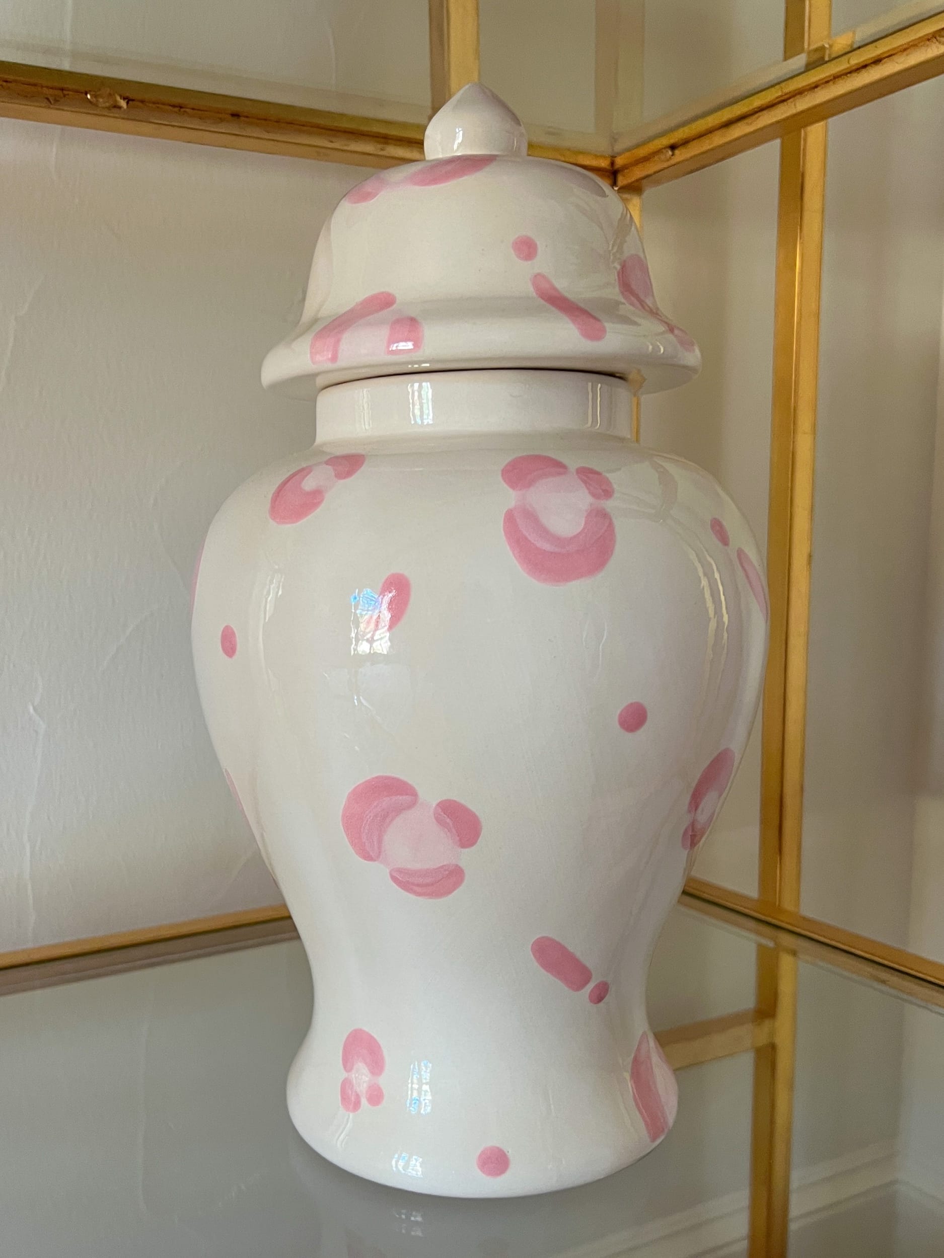 large pink leopard ginger jar sitting on glass shelf