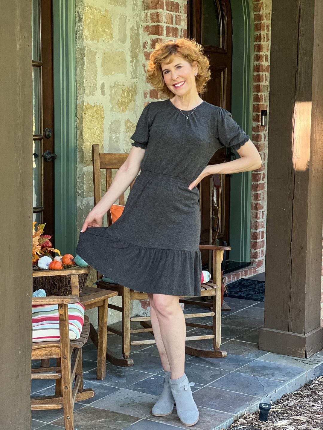 woman stading on a porch wearing loft gray smocked flounce dress