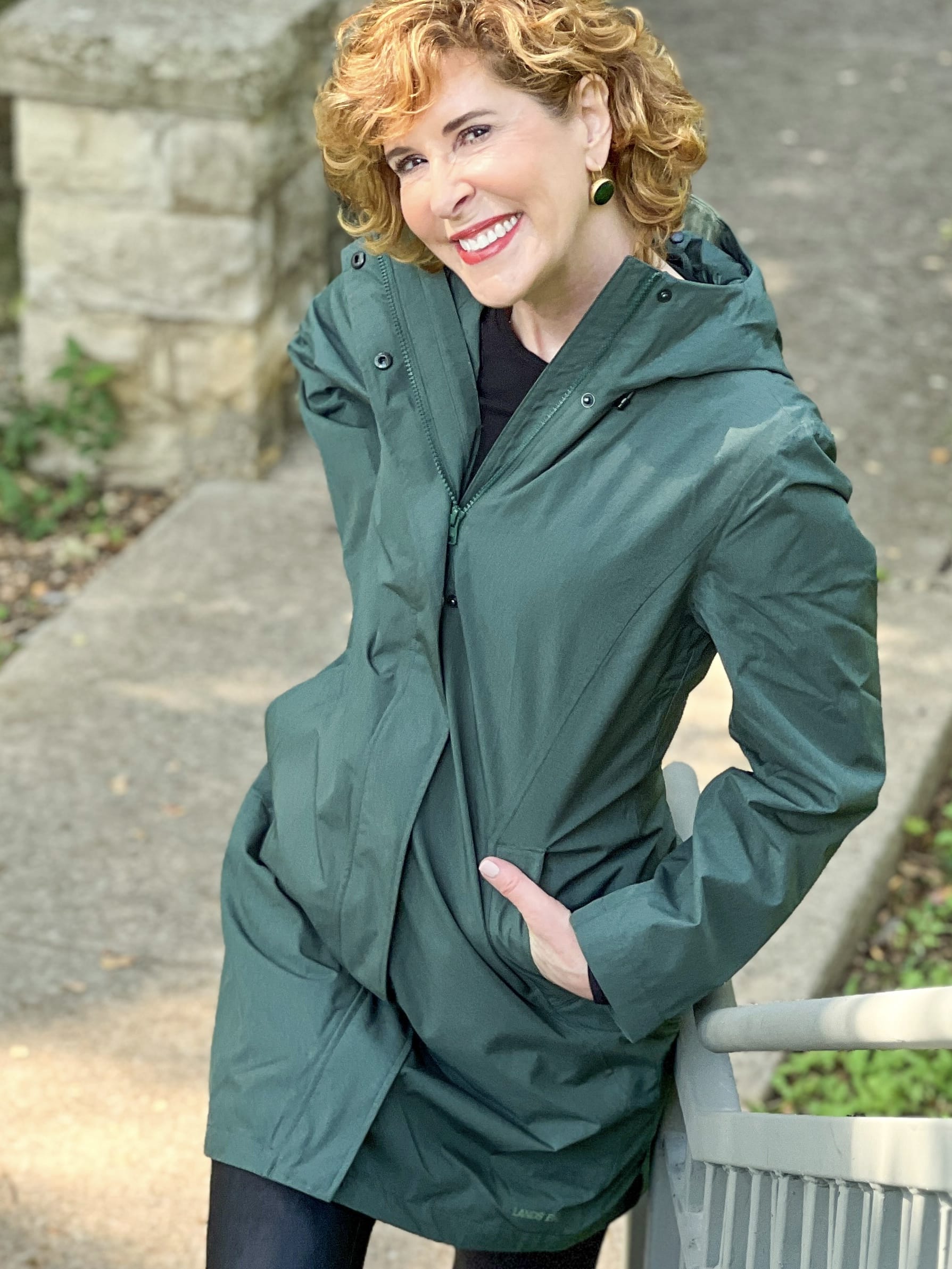woman wearing green land's end Women's Insulated 3 in 1 Primaloft Parka – outer rain coat part - and black leggings standing by a staircase in the park