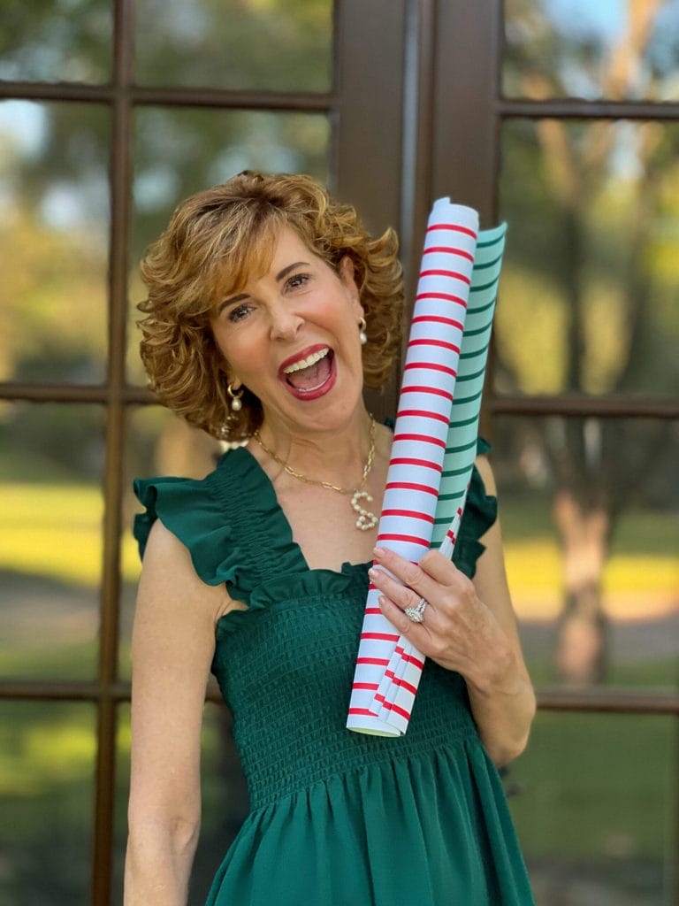 woman wearing green hillhouse home dress holding gift wrap from joy creative shop