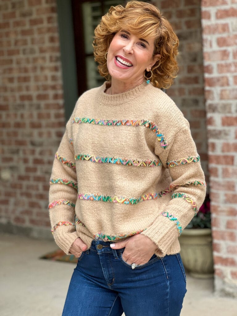 woman over 50 wearing Avara's Lorena sweater in taupe