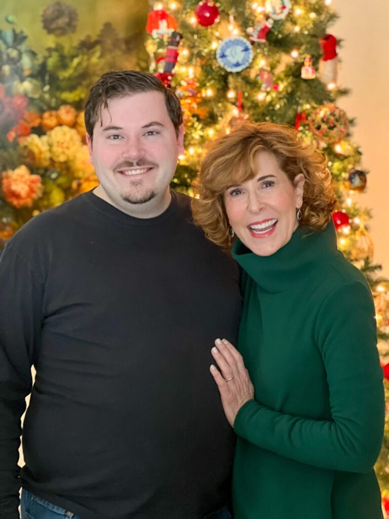 woman and grown son in front of christmas tree
