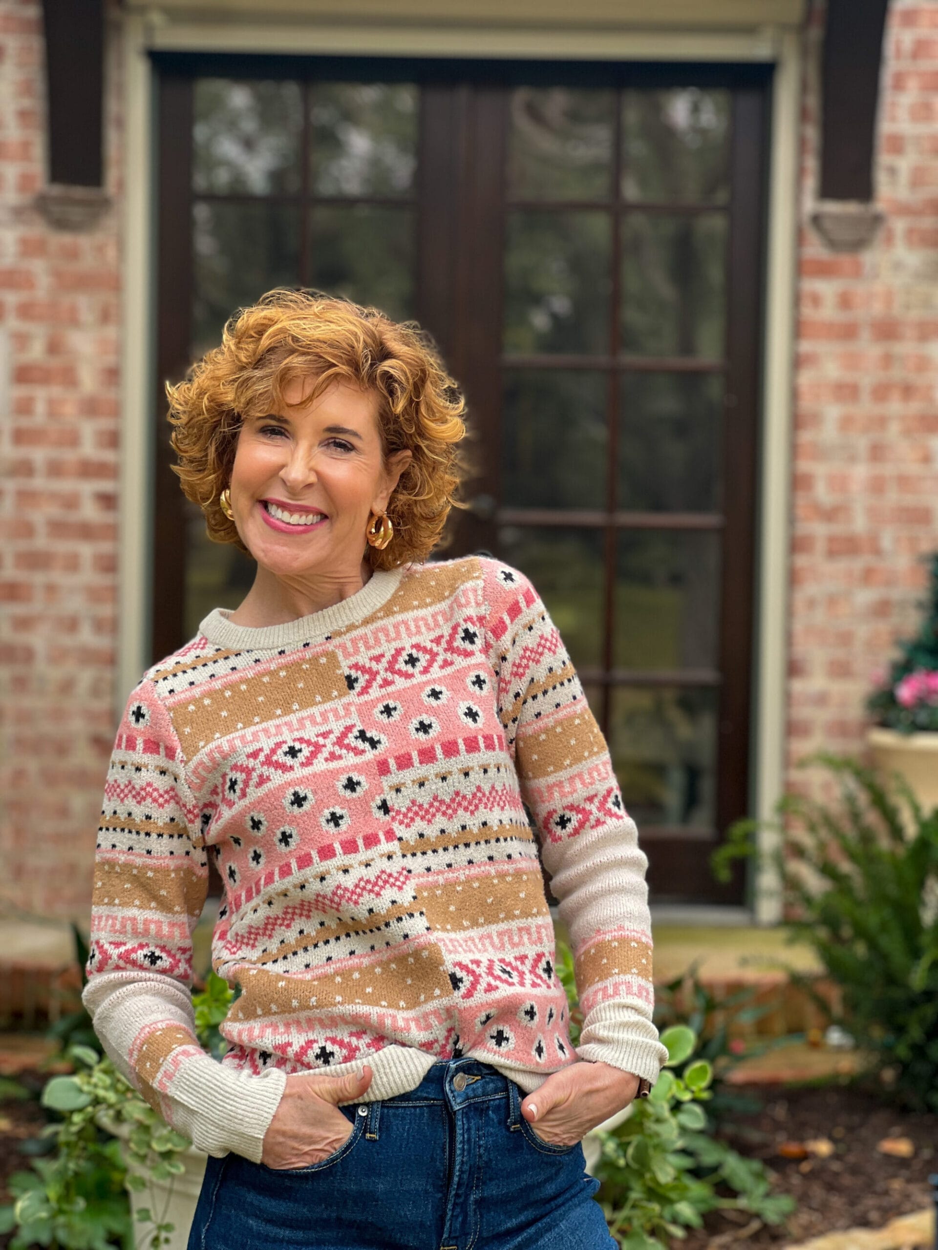 woman over 50 wearing intarsia sweater from walmart standing in front yard showing affordable christmas gifts