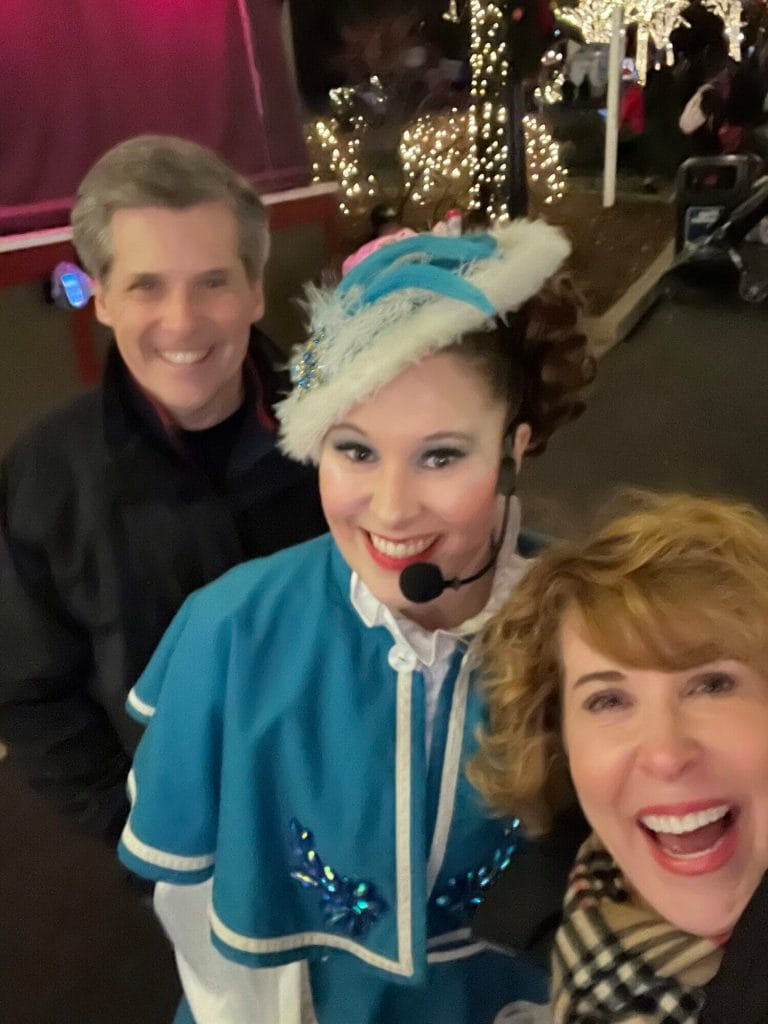 man and woman posing with performer at king's dominion's winterfest