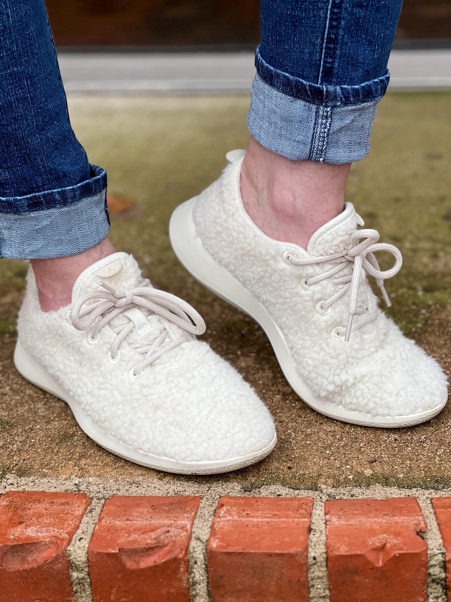 woman wearing allbirds wool fluff sneakers with jeans rolled up