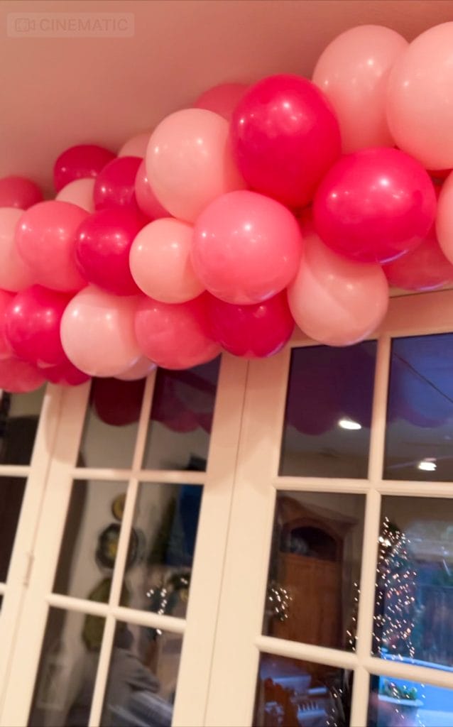 various colors of pink balloons over white doors