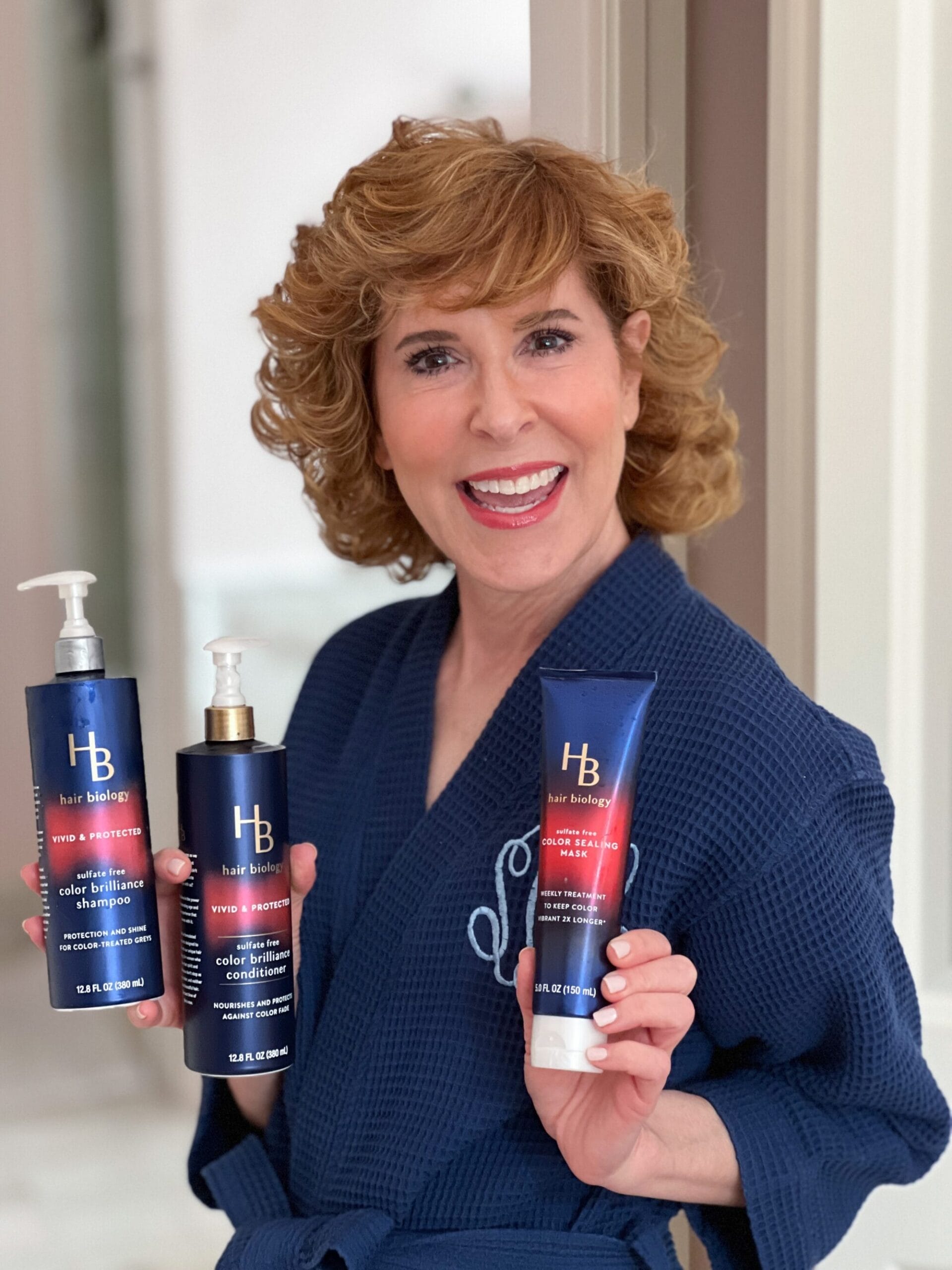 woman over 50 holding hair biology products