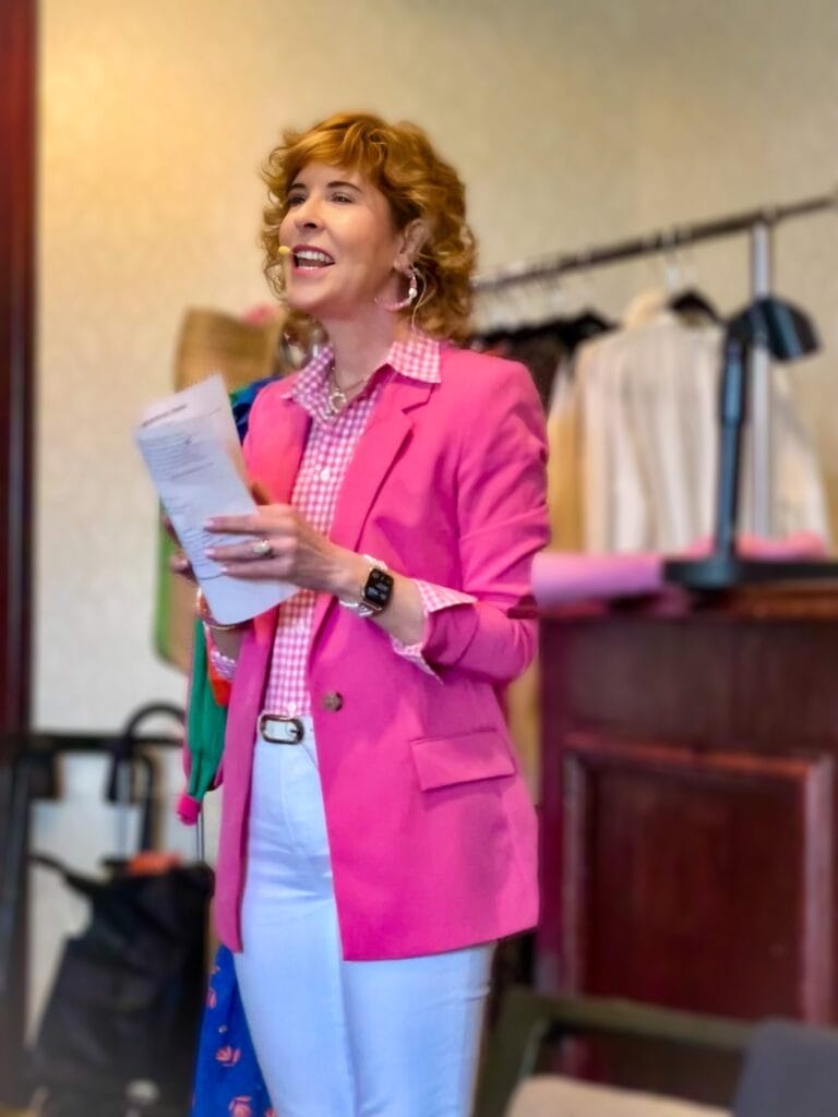 woman dressed in pink blazer speaking to a group