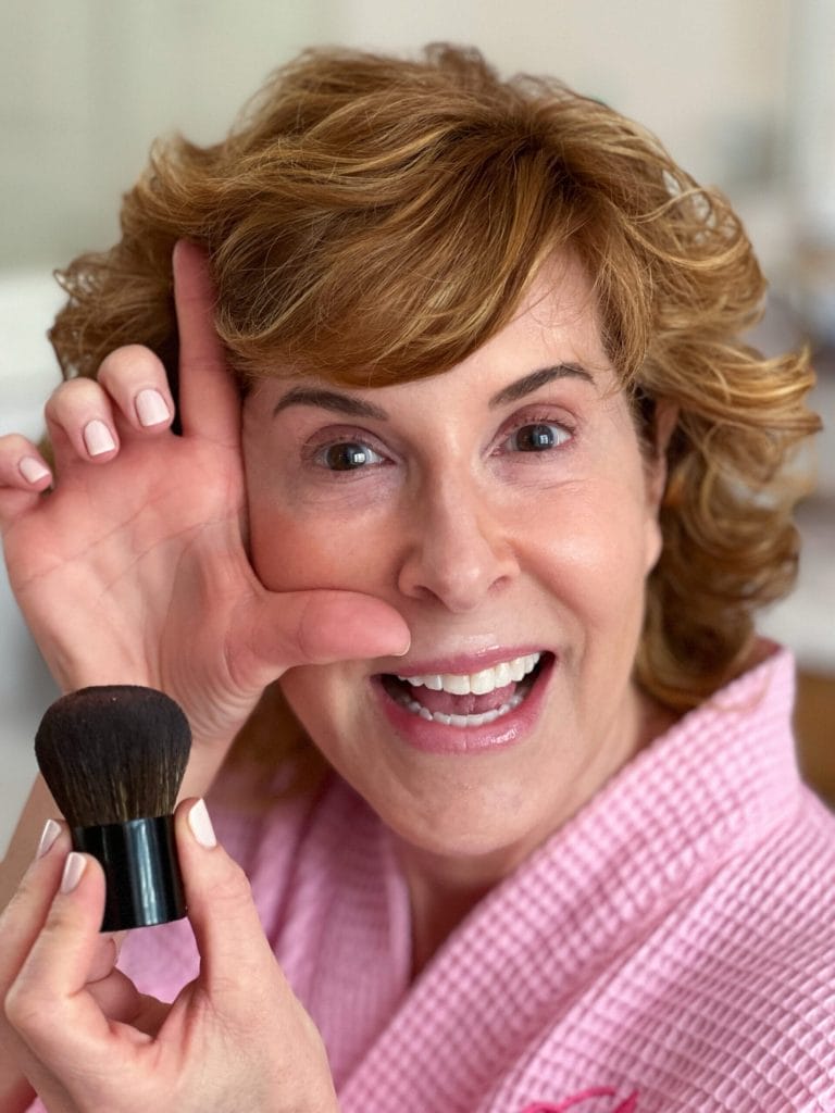 woman demonstrating the L technique of blush placement, a beauty tip for women over 50