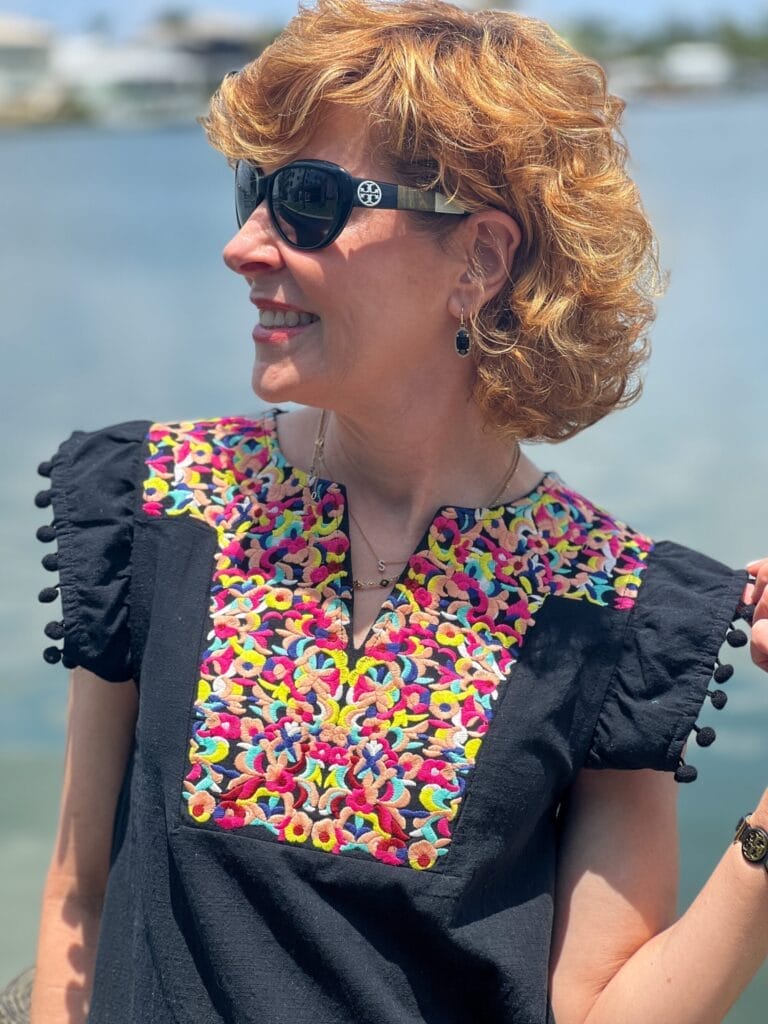 woman wearing amazon black dress with colorful neckline and pom pom sleeves