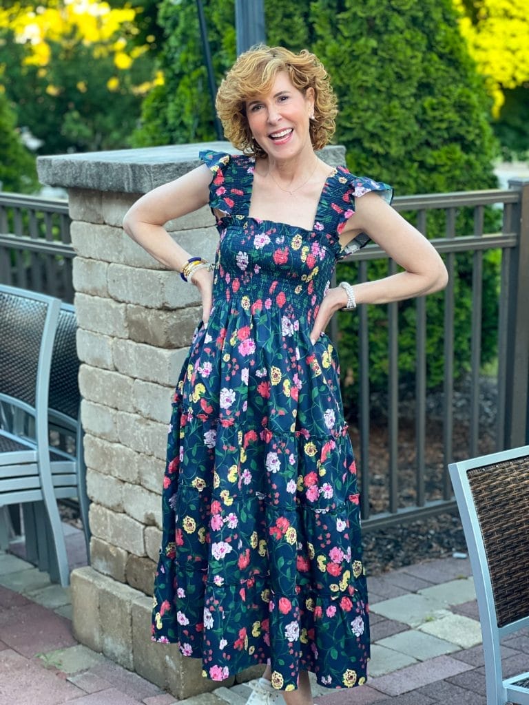 womab wearing floral nap dress standing on a patio