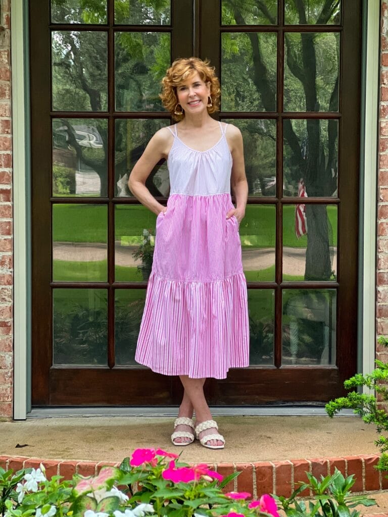 woman standing on porch wearing walmart's free assembly pink midi dress